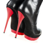 Close-up shot of a pair of fetish boots, high heels with platform, black and red color